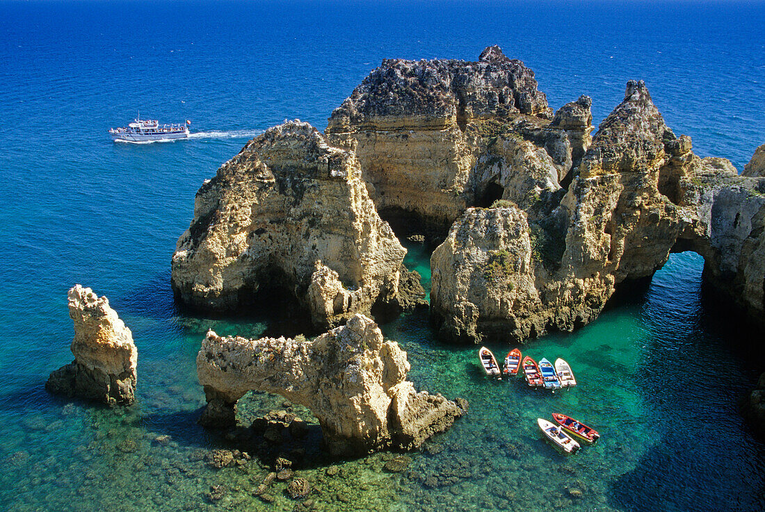 Boats off the rocky coast in the sunlight, Ponta da Piedade, Algarve, Portugal, Europe