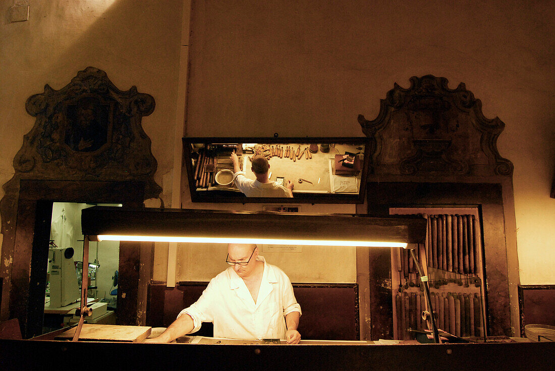 A mature man at an illuminated Scuola del Cuoio, Santa Croce, Florence, Tuscany, Italy, Europe