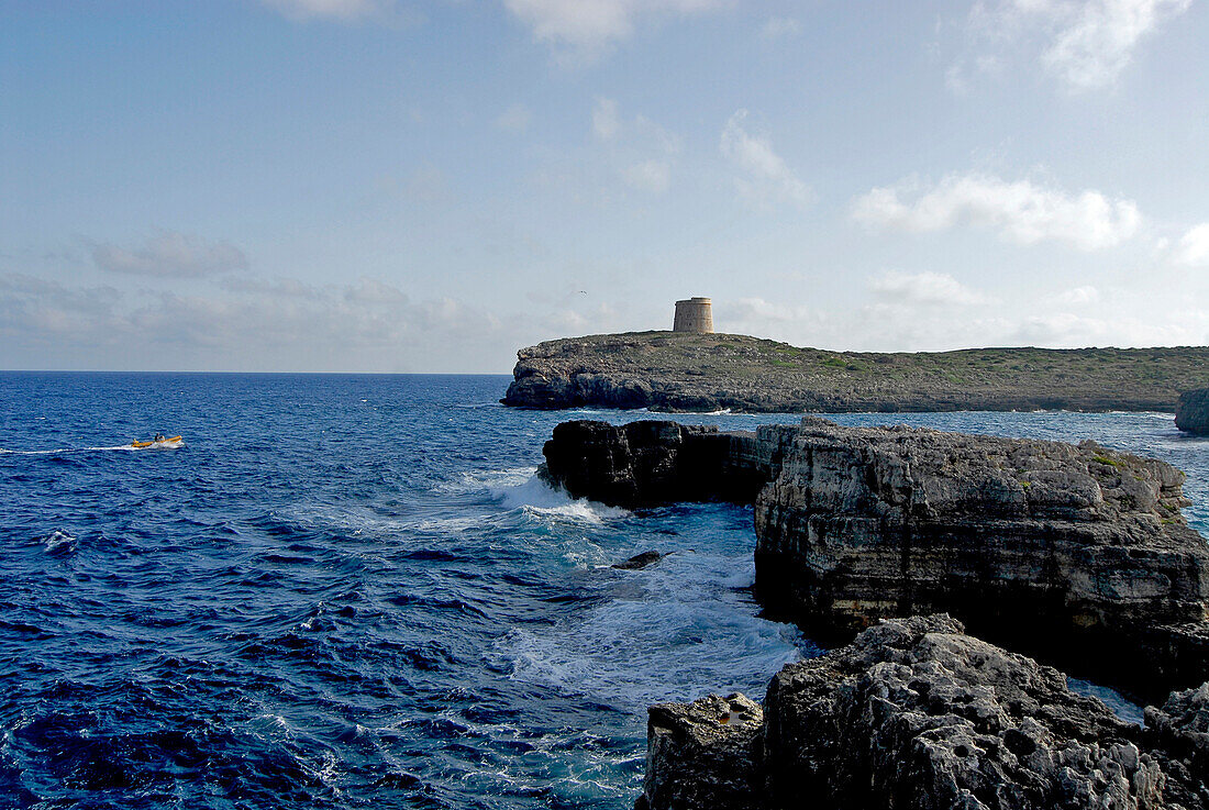 Rocky coast and old tower at the Cala d´Alcaufar, Minorca, Balearic Islands, Spain