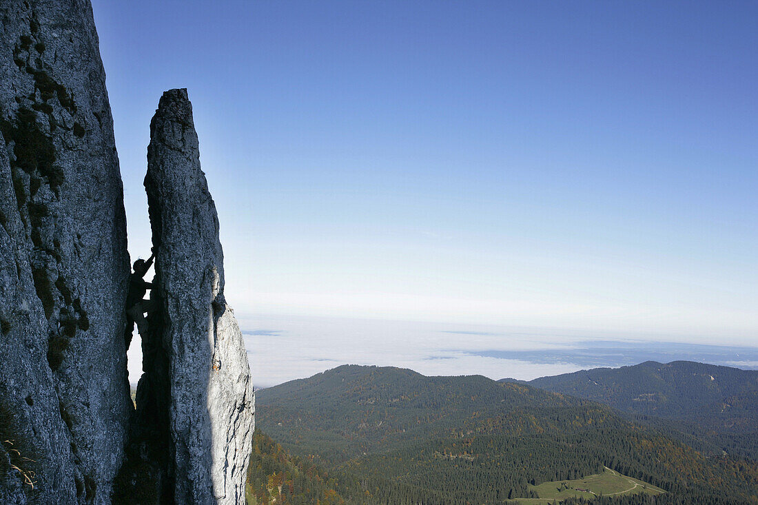 Person klettert in einer Felsspalte, Benediktenwand, Bayern, Deutschland