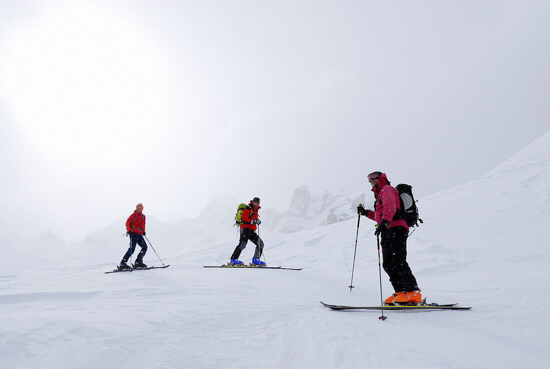 Skiers in diffus light, Cresta Bianca, Cristallo range, Dolomites, Veneto, Italy