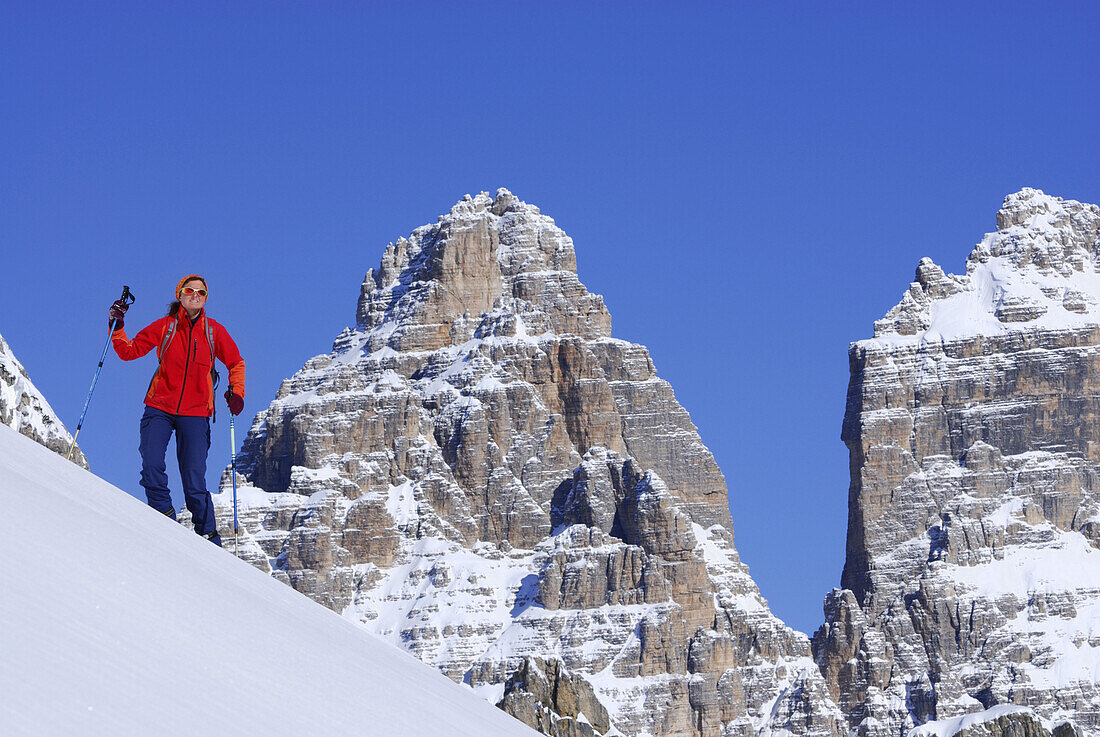 Woman backcountry skiing, Tre Cime Di Lavaredo in background, Cadini range, Dolomites, Trentino-Alto Adige/Südtirol, Italy