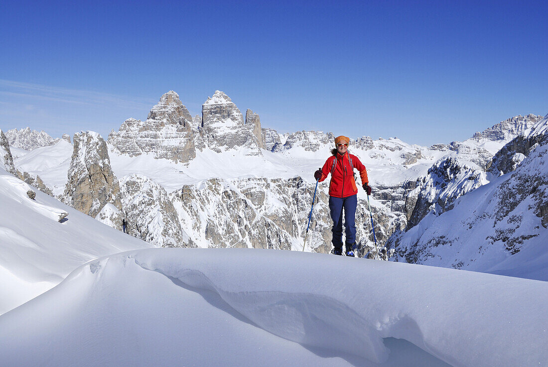 Woman backcountry skiing, Tre Cime Di Lavaredo in background, Cadini range, Dolomites, Trentino-Alto Adige/Südtirol, Italy