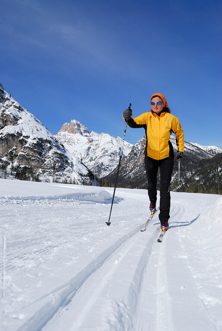 Woman cross-country skiing near Schluderbach, Cristallo range, Dolomites, Veneto, Italy