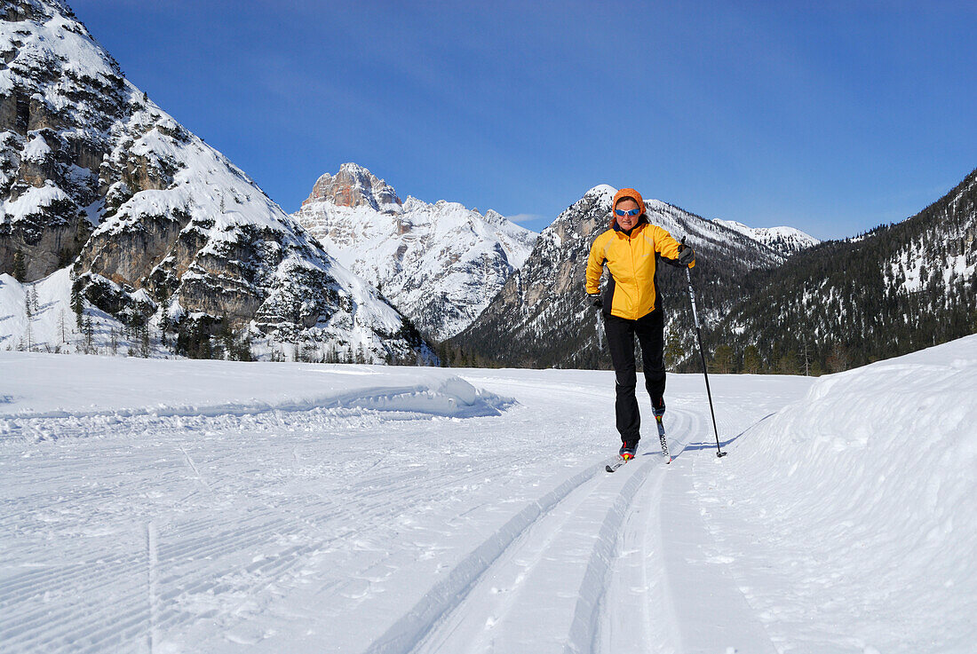 Woman cross-country skiing near Schluderbach, Cristallo range, Dolomites, Veneto, Italy