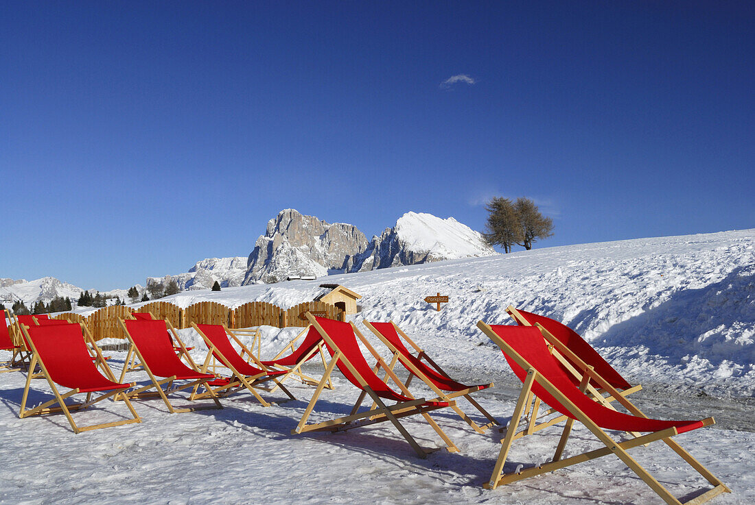 Red deckchairs in snow, Seiser Alm, Dolomites, Trentino-Alto Adige/Südtirol, Italy