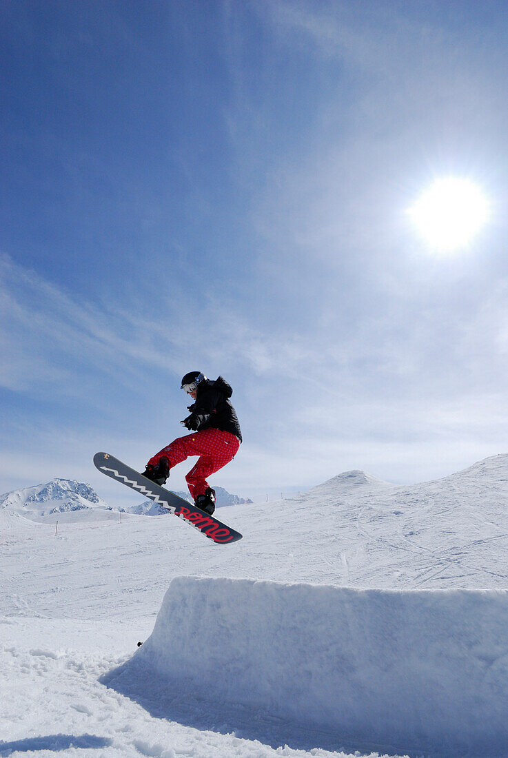 Snowboarder beim Sprung von einer Schanze, Skigebiet Sölden, Ötztal, Tirol, Österreich