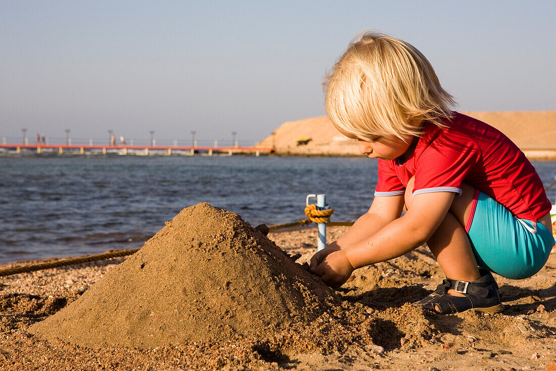 Kleines Kind, 3, Mädchen spielt im Sand am Strand des Lamaya Resort, Coraya, Marsa Alam, Aegypten