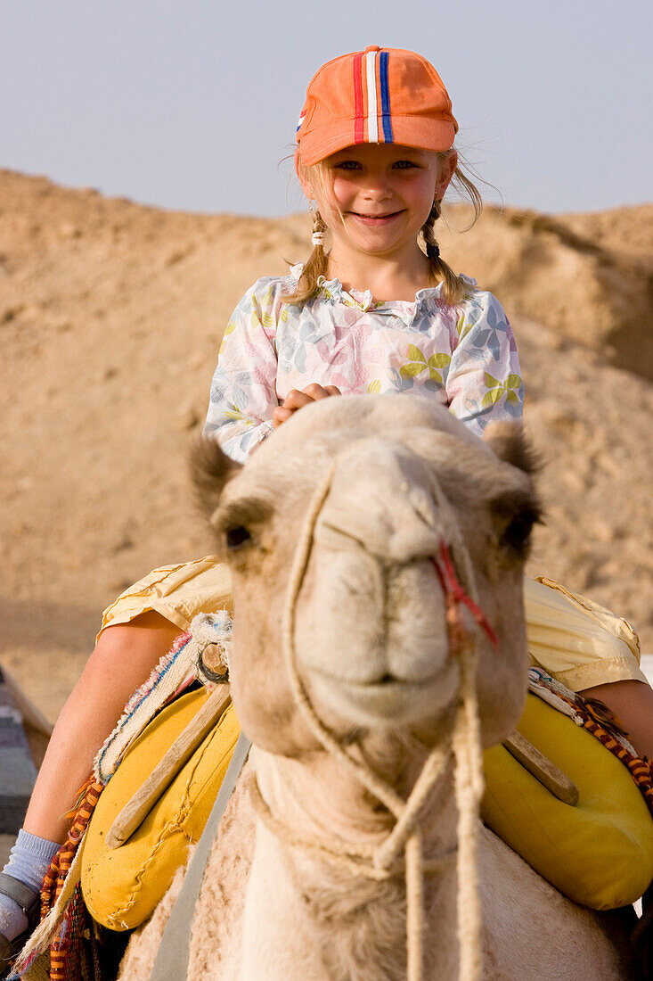 Kind, Mädchen, 5, reitet auf Kamel, Dromedar in der Wüste von Marsa Alam, Rotes Meer, Aegypten