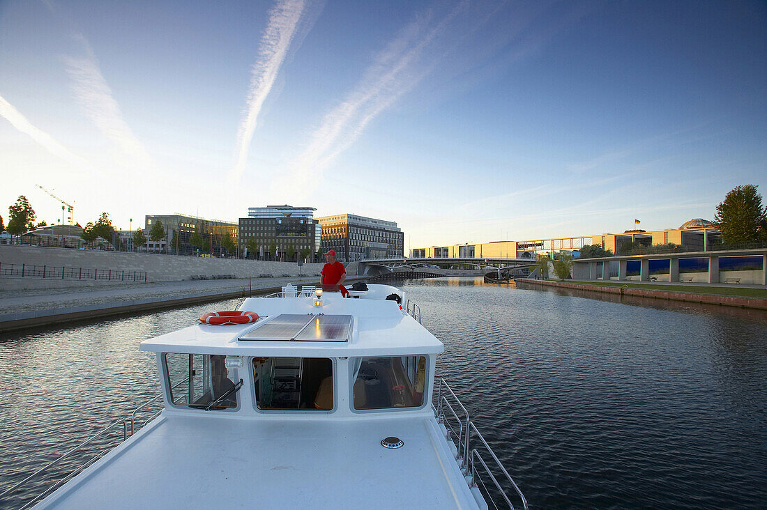Houseboat on river Spree, government district in background, Berlin, Germany
