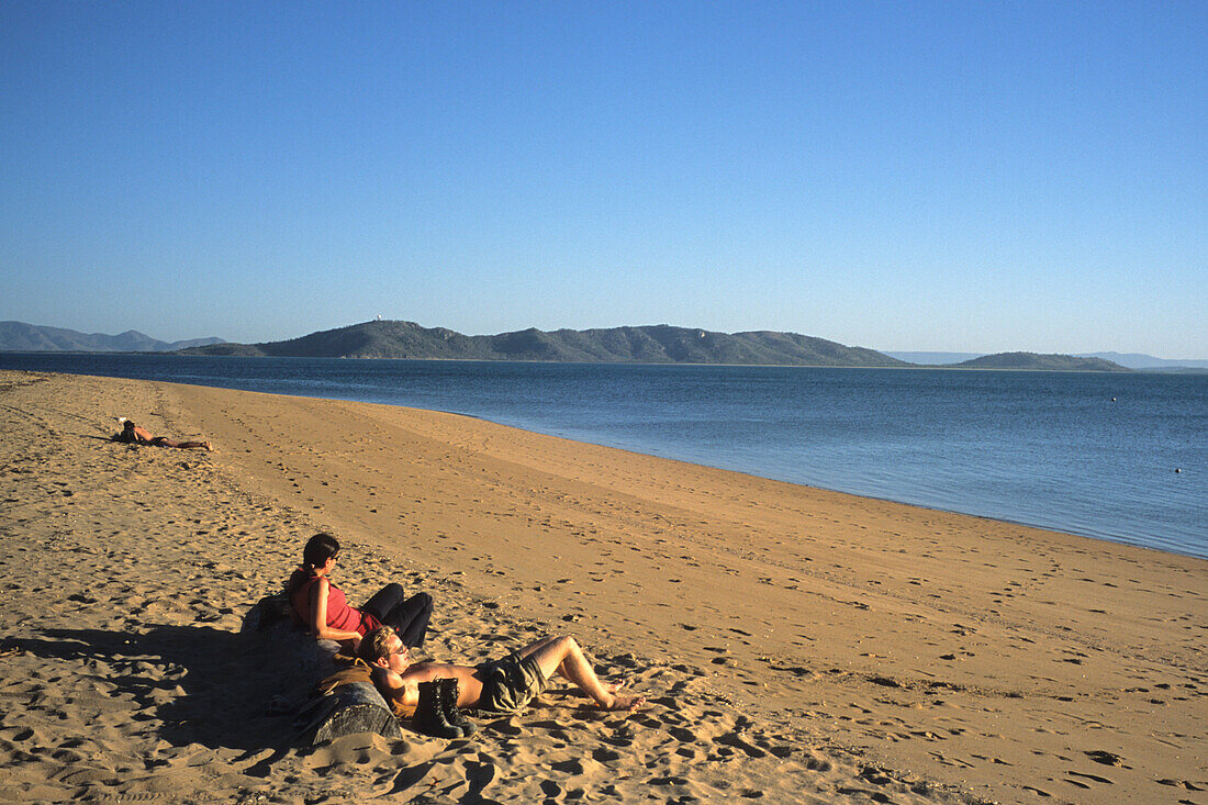 Couple relaxing on West Point Beach, Magnetic Island, Queensland, Australia