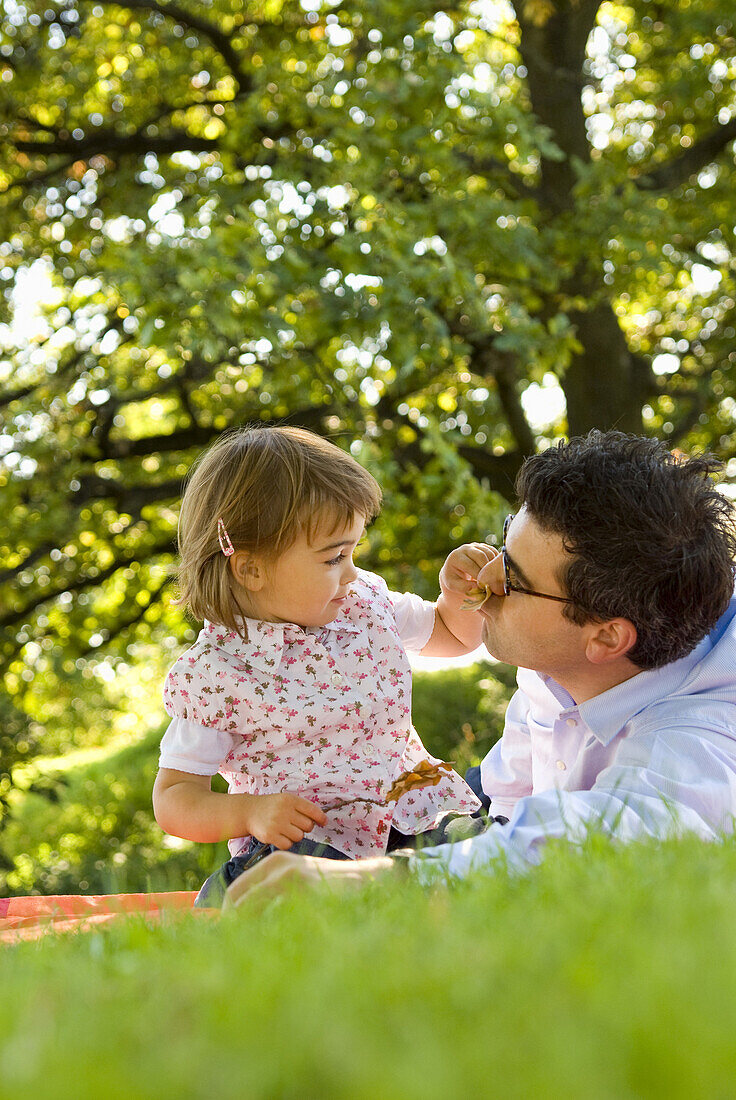 Vater und Tochter spielen auf einer Wiese, Englischer Garten, München, Bayern, Deutschland
