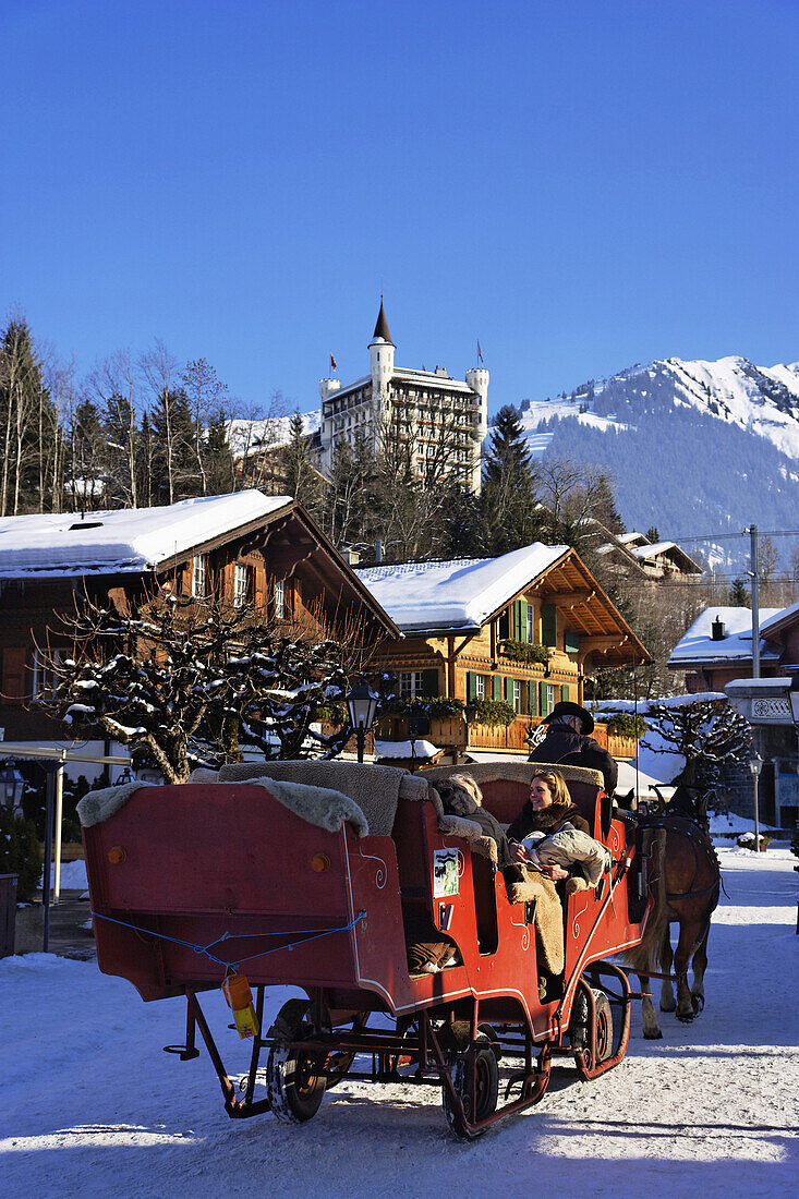 Horse-drawn sleigh on promenade, Palace Hotel in background, Gstaad, Bernese Oberland, Canton of Berne, Switzerland