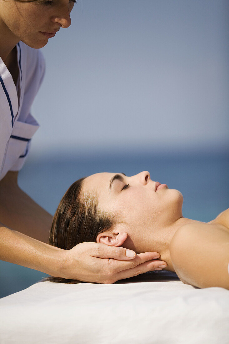 Young woman having a massage by the sea.