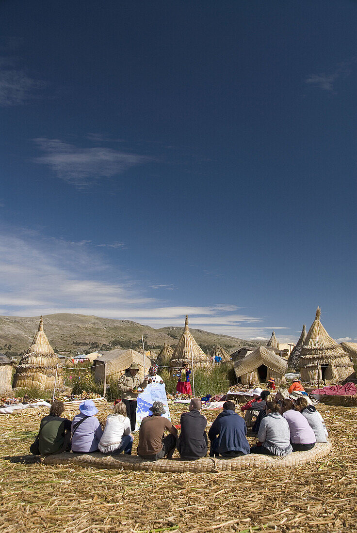 Peru, Lake Titicaca, floating islands of the Uros people, guide lecturing to tourists