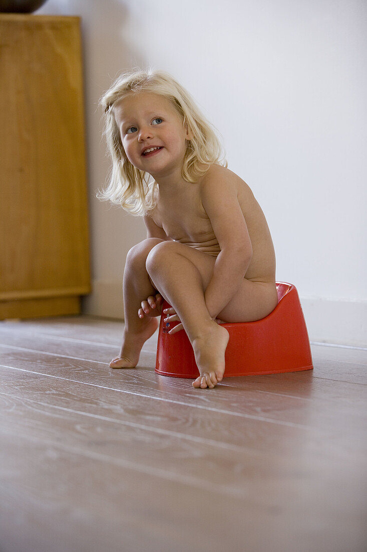 Blond little girl is sitting on a potty
