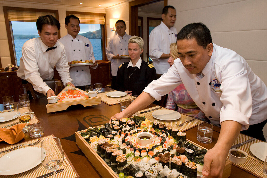 Kellner servieren Sushi an Bord einer Yacht, Shetland Inseln, Schottland, Großbritannien