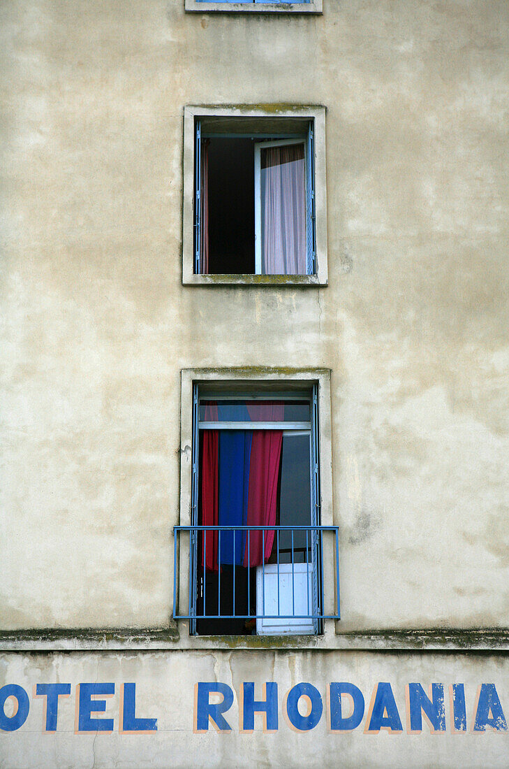 Window with curtain and facade of Hotel Rhodania, Arles, France, Europe