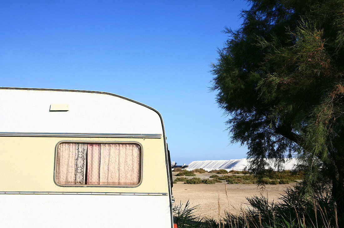 Vorhang in einem Wohnwagen, im Hintergrund die Saline von Giraud, Camargue, Frankreich, Europa