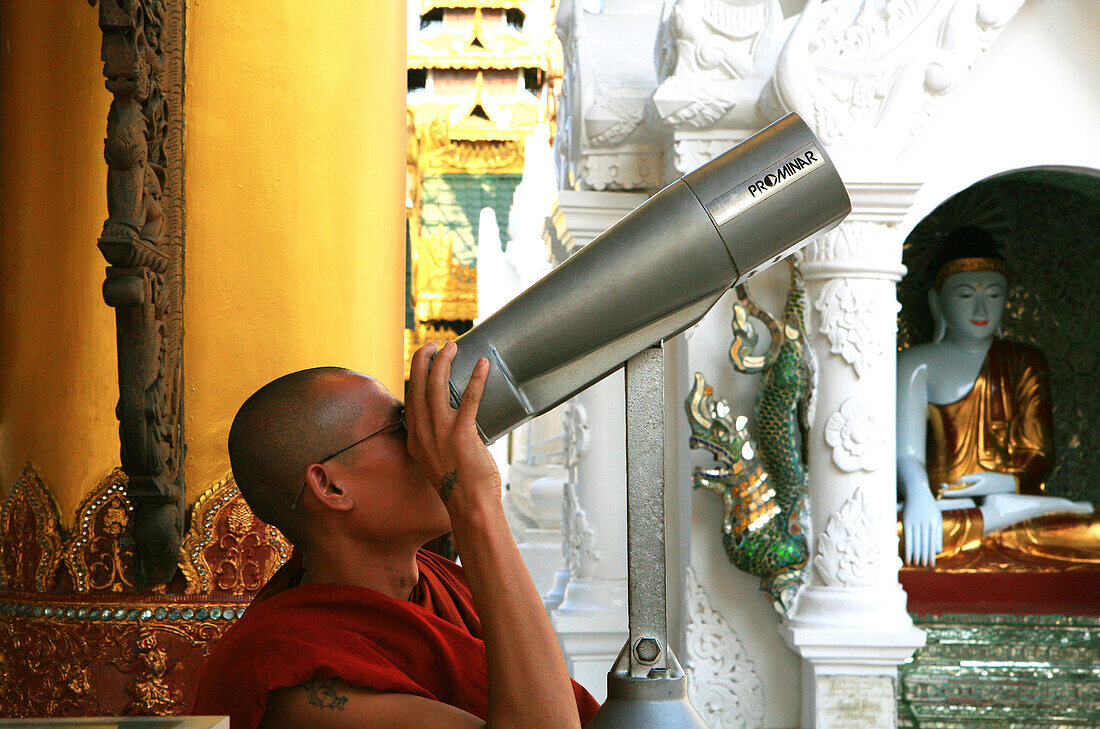 Buddhistischer Mönch schaut durch ein Fernrohr, Shwedagon Pagode, Rangoon, Myanmar, Birma, Asien