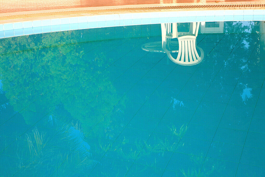 A chair reflecting in the pool of the Golden Express Hotel, Bagan, Myanmar, Burma, Asia