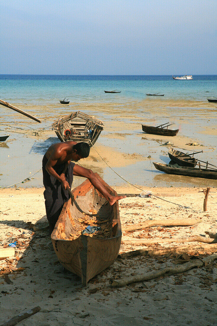 Seezigeuner, Moken Mann baut ein Einbaum Boot am Strand, Mergui Archipel, Andamanensee, Myanmar, Birma, Asien