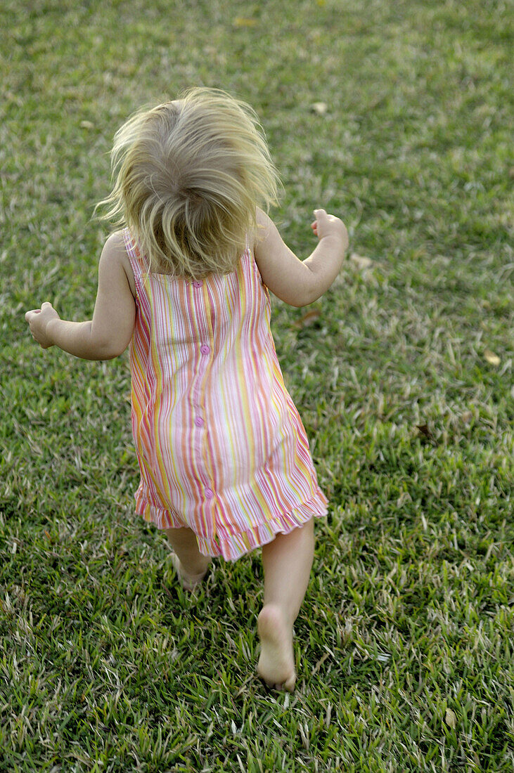 16 months old toddler running in the grass