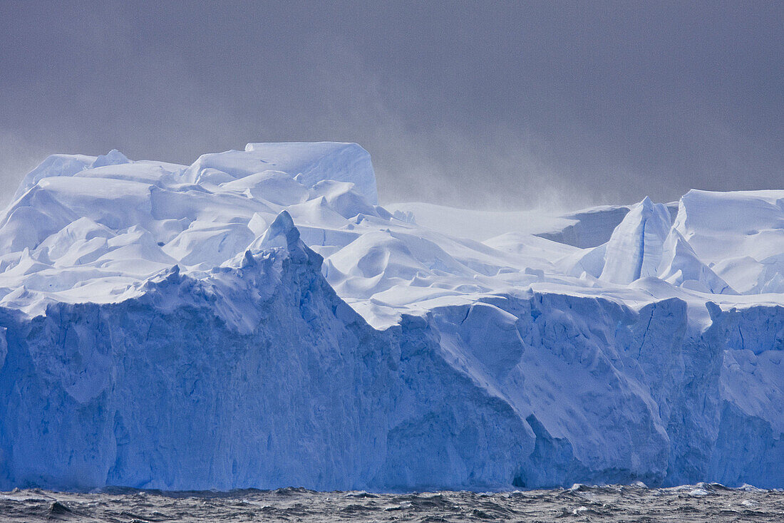 Fierce gale-force winds carving tabular icebergs below the Antarctic Circle around the Antarctic Peninsula during the summer months  More icebergs are being created as global warming is causing the breakup of major ice shelves and glaciers