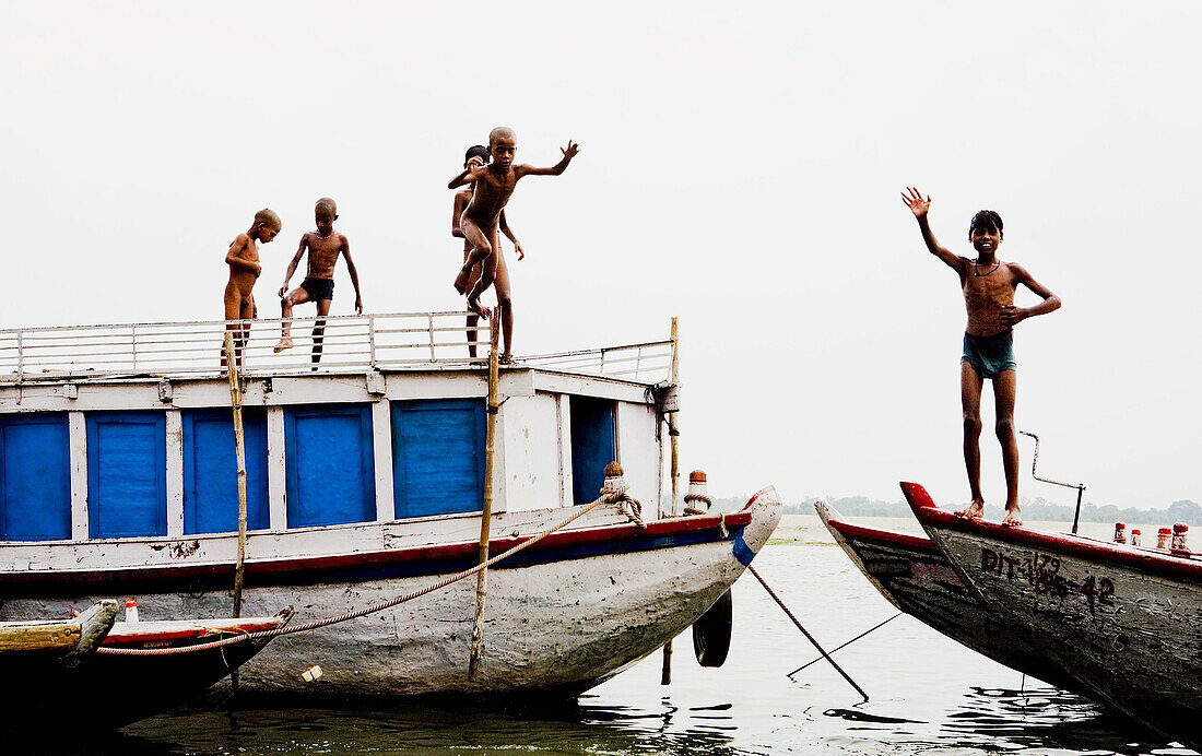10 to 15 years, 10-15 years, Bathing, Boats, Boys, Counting, Diving, Fingers, Ganga, Ganges River, India, Naked, Religious, River, Smile, Varanasi, Water, Waving, F17-704600, agefotostock