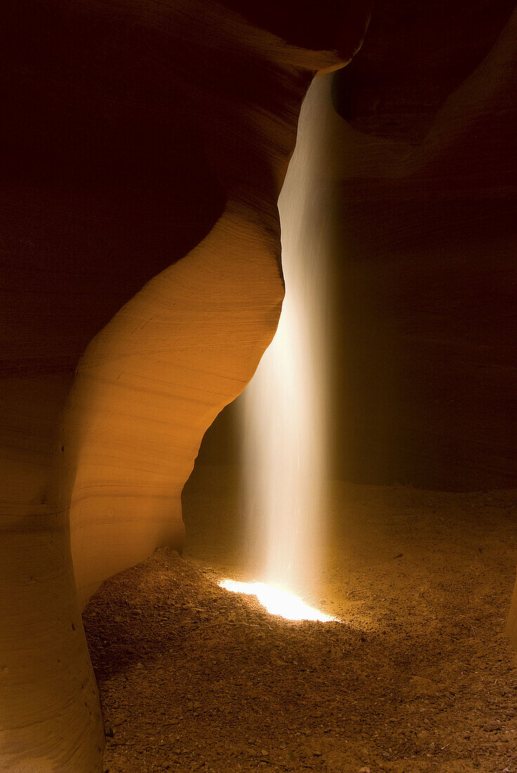 Shaft of sunlight in slot canyon, Canyon X, near Page, Arizona, USA