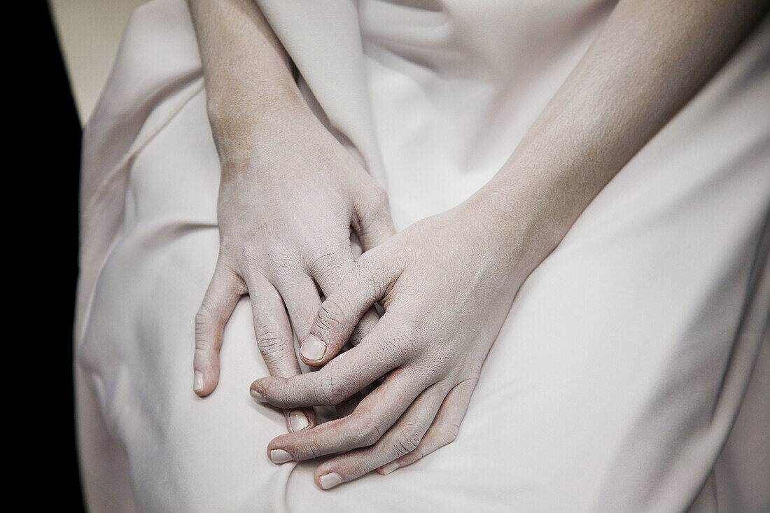 Die Hände eines Mädchens sind mit weißer Schminke bedeckt