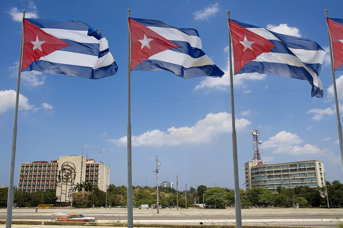 Cuban flags and Ministry of the Interior (Ministerio del Interior) building with Che Guevara bronze wire sculpture in background, Havana. Cuba