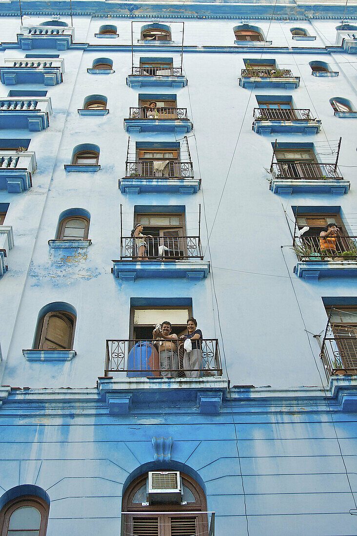 A view of people on a buildings balconies.