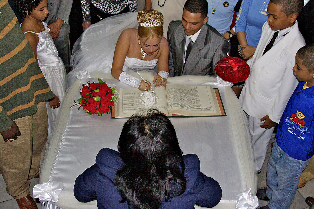 The bride signing the offical record book at her wedding ceremony.