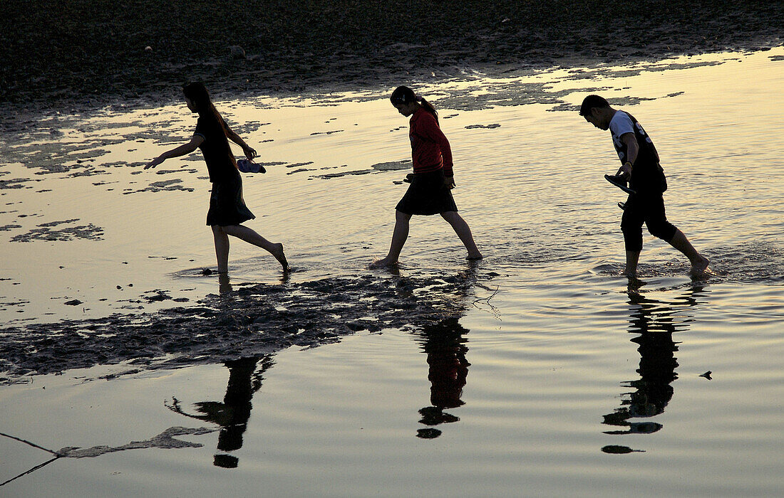 Tree Lao People crossing part of  Mekong River, Vientiane, Laos