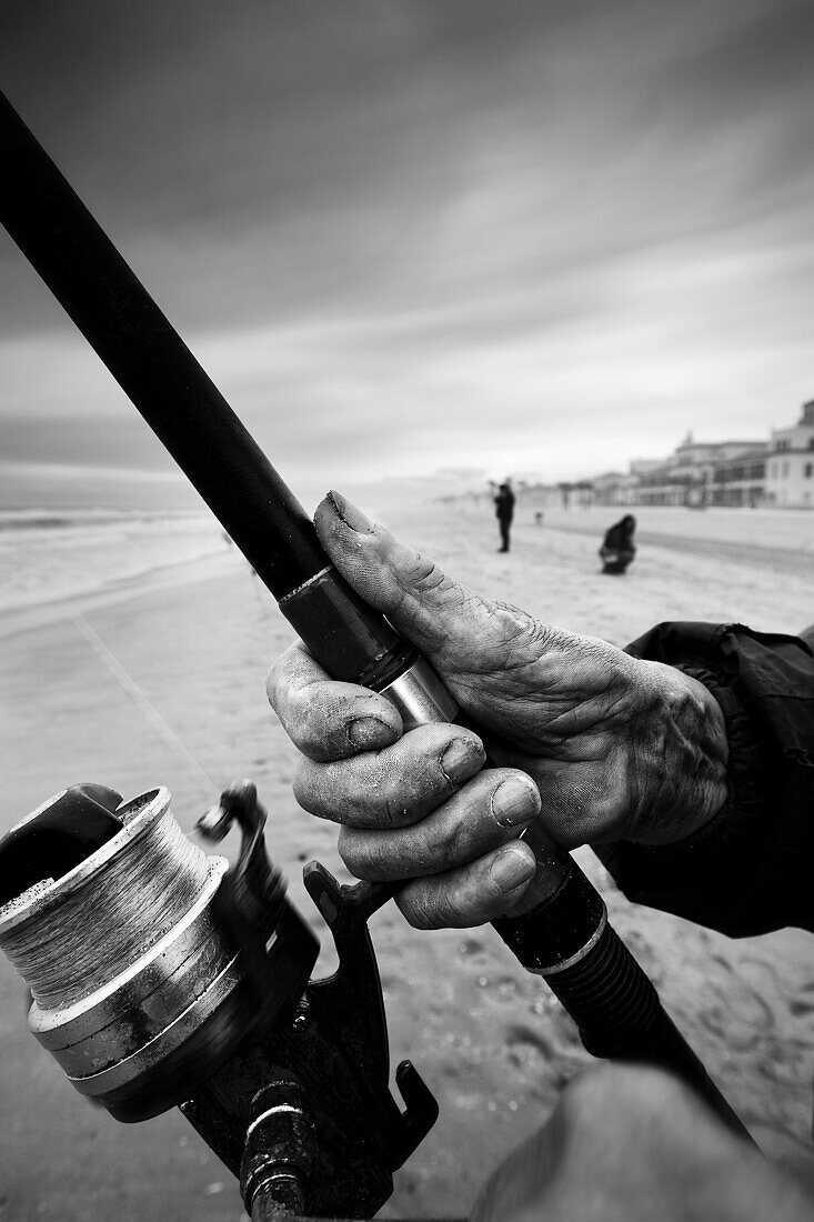 Primer plano manos de pescador de caña. En la Playa. Costa Dorada (Tarragona). Spain.