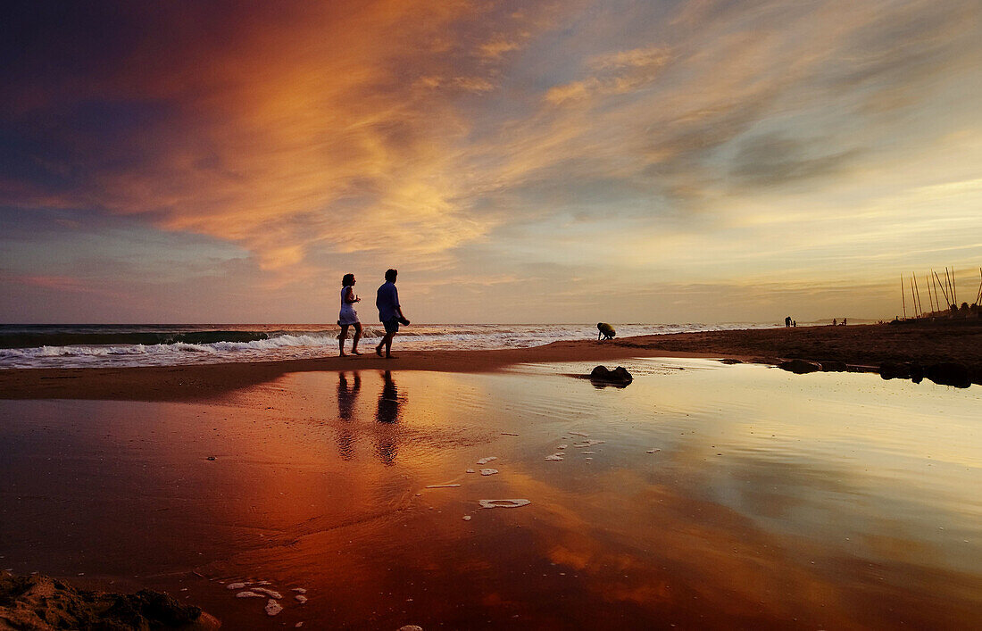 Paseo por la playa en un rojo atardecer después de la tormenta. Costa Dorada, Cataluña. Spain.