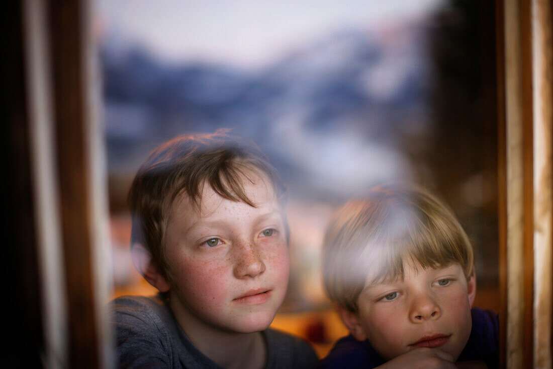 Two boys looking out a window, Brixen, Tyrol, Austria