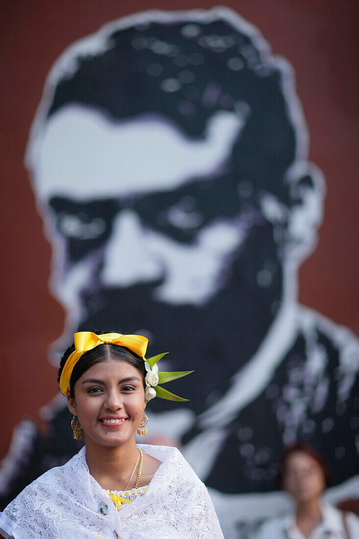 Frau in traditioneller Kleidung vor Wandmalerei, Oaxaca, Mexiko