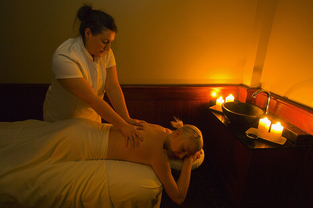 A woman receiving a massage by candlelight, Temple Mountain Spa, Post Hotel & Spa, Lake Louise, Alberta, Canada