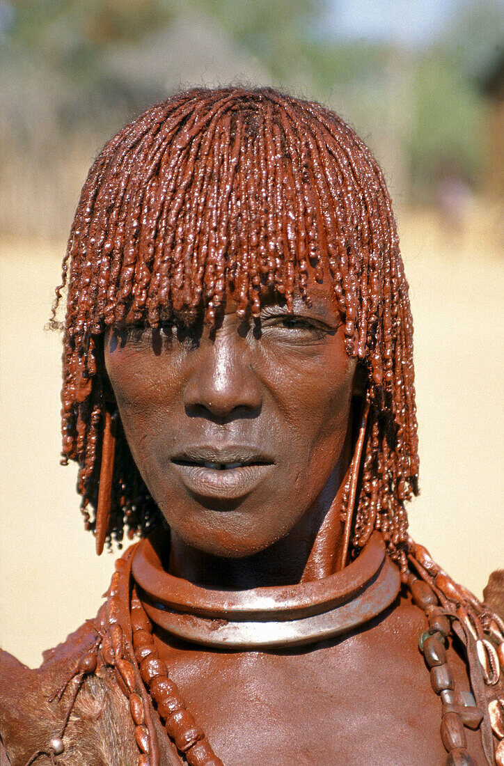 Hamer woman caked in mud and beads in the Omo Valley of Ethiopia