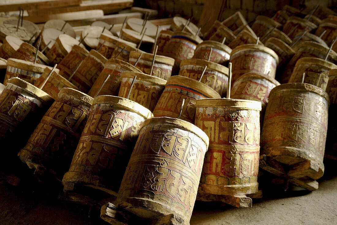 A cylinder containing or inscribed with prayers or litanies that is revolved on its axis in devotions, especially by Tibetan Buddhists