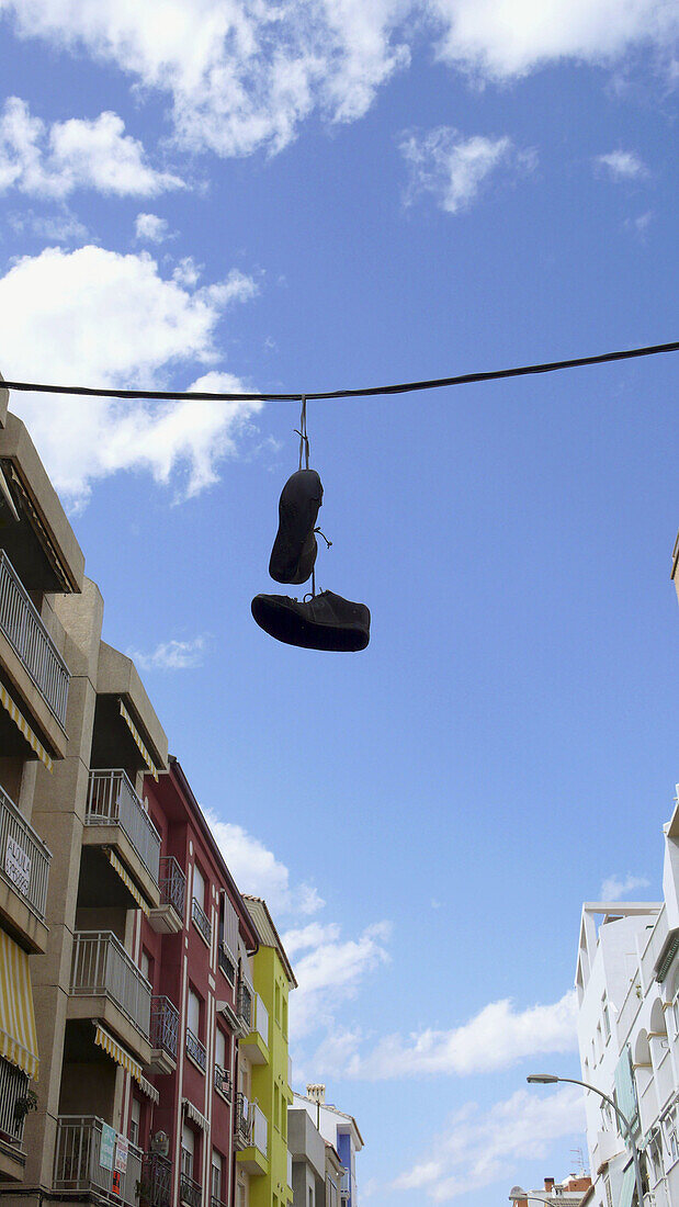 Sneakers hanging on cable. Gandia, Valencia province, Comunidad Valenciana, Spain