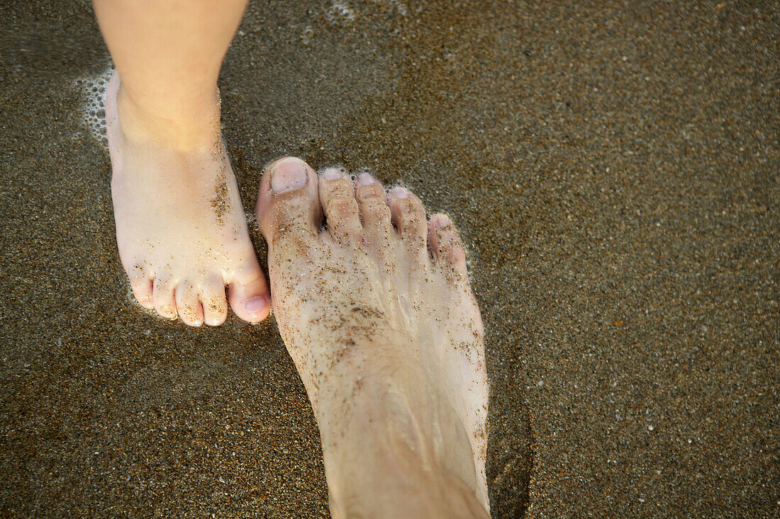 Baby und Vater Füße auf dem Sand