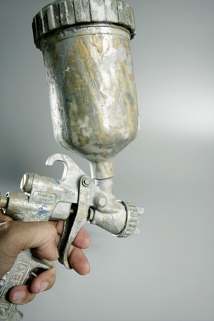 Silver paint air gun in operators hand