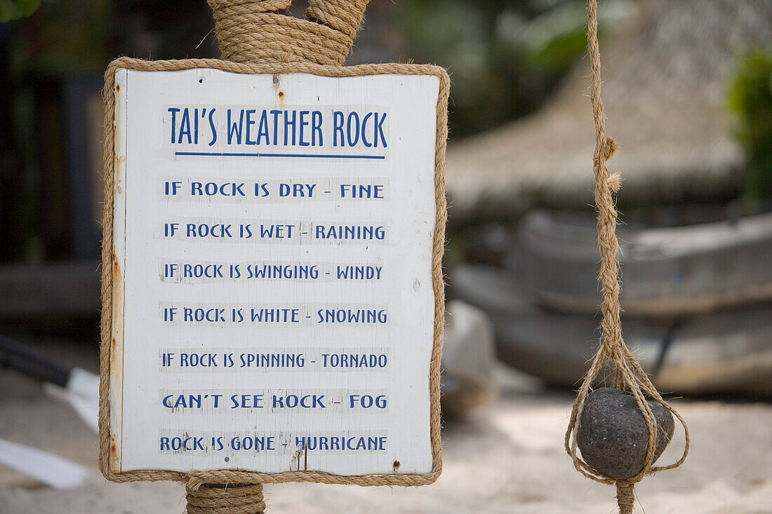 A sign and a stone, Tai's Weather Rock at Muri Beach, Rarotonga, Cook Islands, Oceania