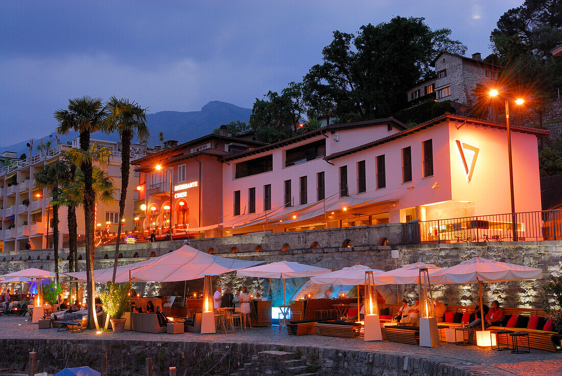 Bar unter Schirmen an Strandpromenade von Ascona, beleuchtet, Ascona, Lago Maggiore, Tessin, Schweiz