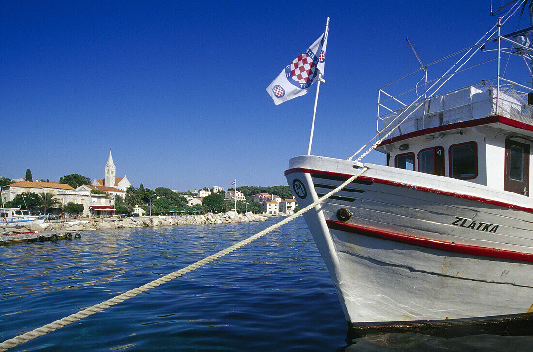 Boot im Hafen des Dorfes Sumartin unter blauem Himmel, Insel Brac, Kroatische Adriaküste, Dalmatien, Kroatien, Europa