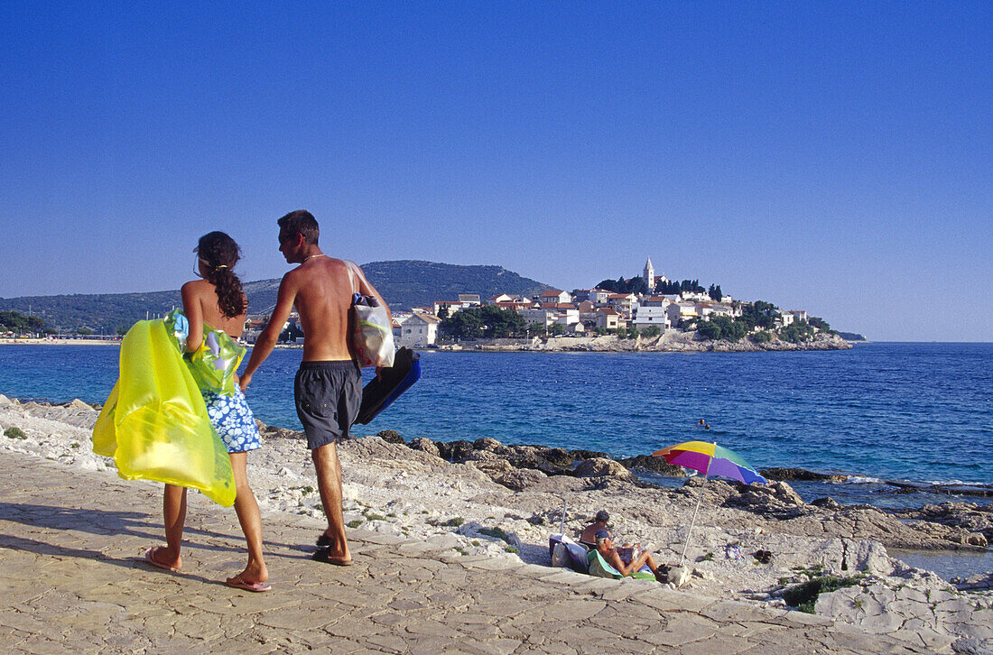 People on the seaside promenade under blue sky, Primosten, Croatian Adriatic Sea, Dalmatia, Croatia, Europe
