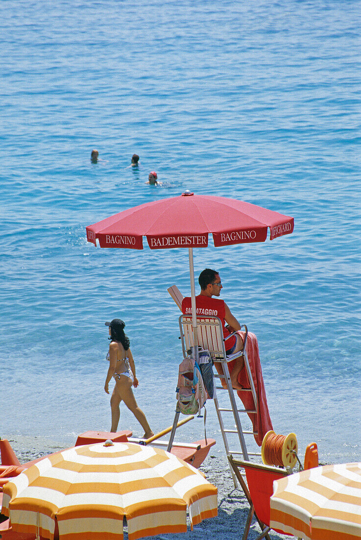 Bademeister am Strand unter einem Sonnenschirm, Monterosso al Mare, Cinque Terre, Italienische Riviera, Ligurien, Italien, Europa